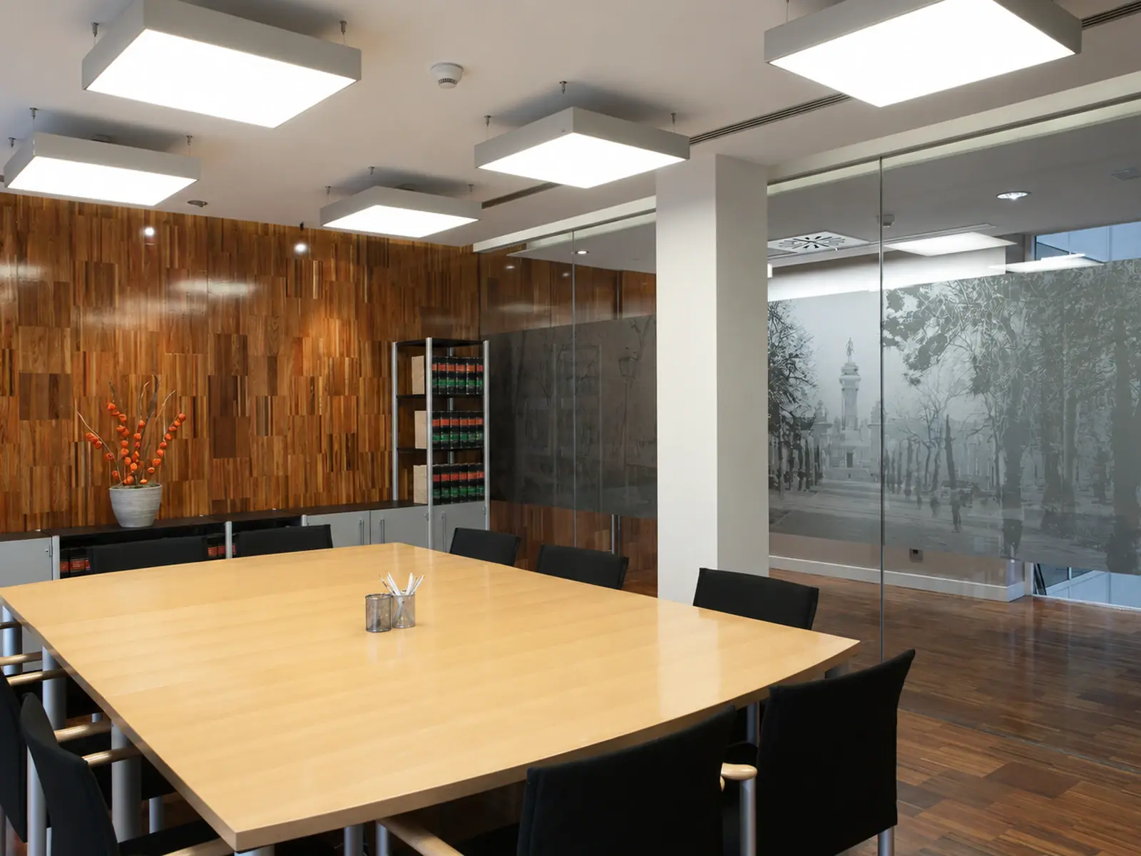 Sala de reuniones de oficinas en Madrid, con cerramientos de vidrio y revestimientos de madera