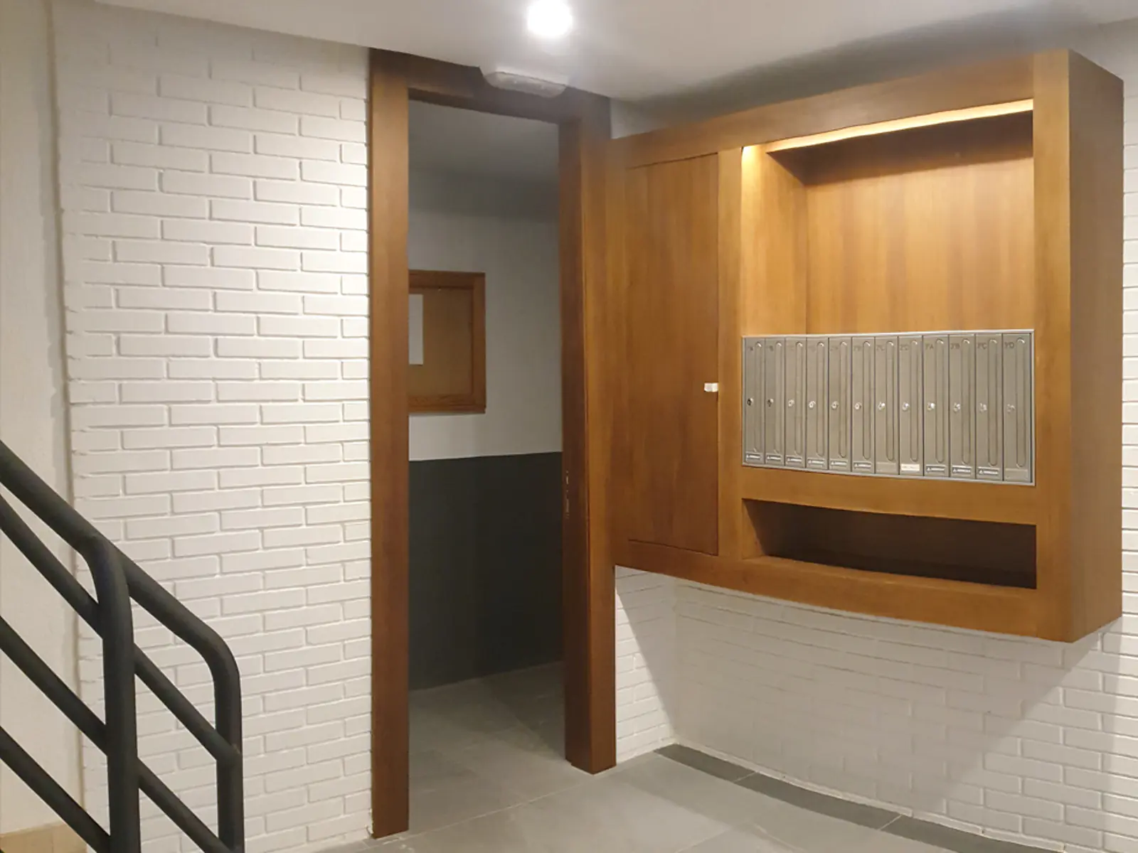 Buzones integrados en un mueble de madera en el mismo portal objeto del proyecto de accesibilidad