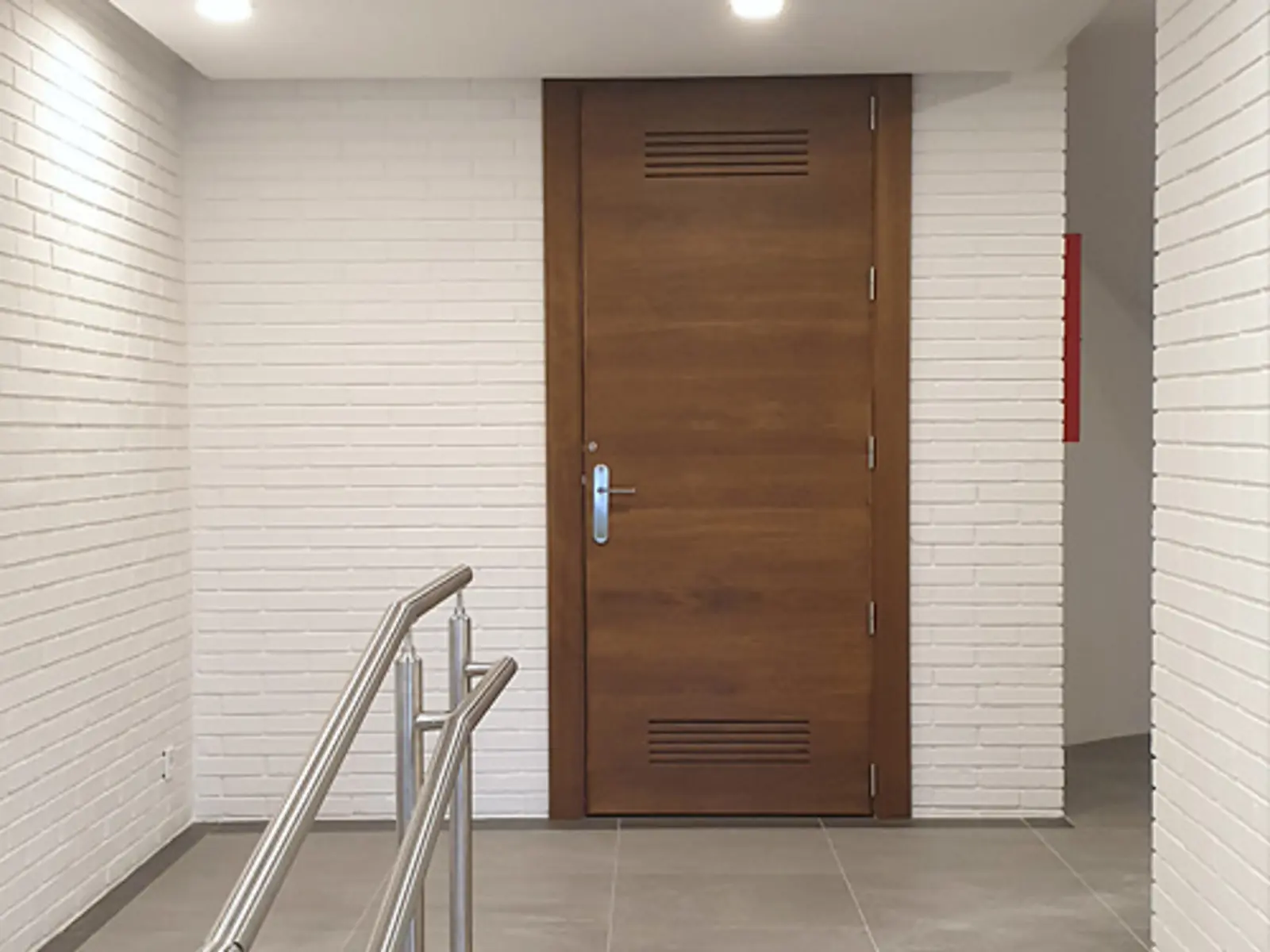 Recorrido con rampa y barandilla del portal acondicionado para mejorar la accesibilidad y la puesta a cota cero