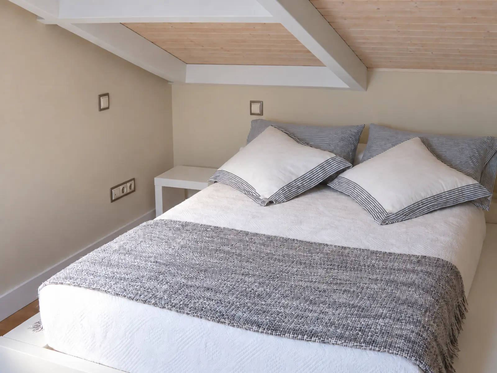 Dormitorio acondicionado bajo la nueva cubierta de madera de la vivienda unifamiliar